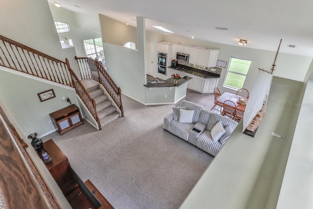 12 S Lakewalk Dr, Palm Coast, FL 32137 - living room featuring light carpet, baseboards, stairs, and vaulted ceiling