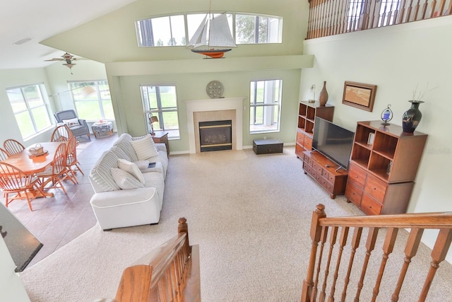 12 S Lakewalk Dr, Palm Coast, FL 32137 - living area with ceiling fan, healthy amount of natural light, a glass covered fireplace, a high ceiling, and baseboards