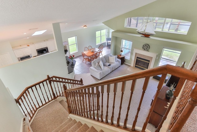 stairs featuring tile patterned floors, a textured ceiling, and a healthy amount of sunlight