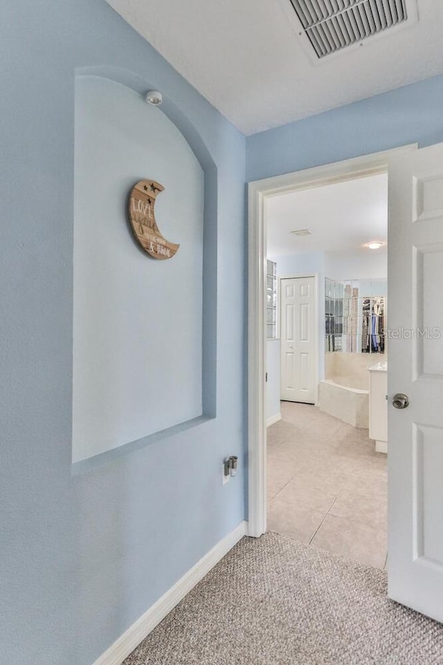 12 S Lakewalk Dr, Palm Coast, FL 32137 - hall with baseboards, light carpet, and light tile patterned floors