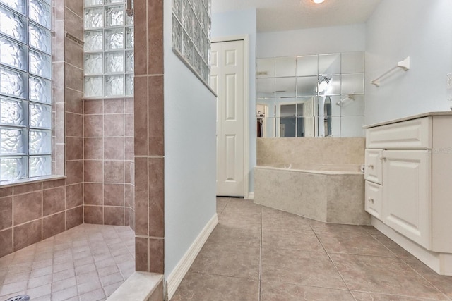 bathroom with tile patterned flooring, vanity, and shower with separate bathtub