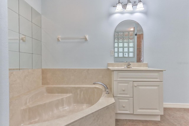 bathroom with tile patterned flooring, vanity, and tiled bath