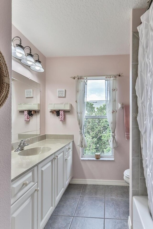 12 S Lakewalk Dr, Palm Coast, FL 32137 - full bathroom featuring vanity, tile patterned flooring, toilet, a textured ceiling, and baseboards