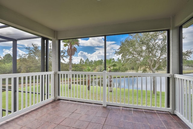 unfurnished sunroom featuring a water view