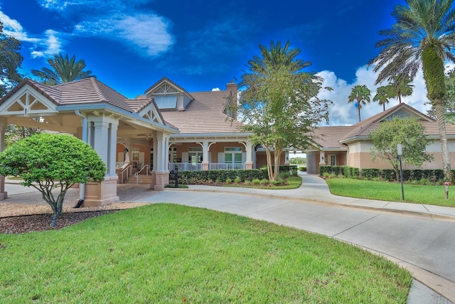 12 S Lakewalk Dr, Palm Coast, FL 32137 - view of front facade featuring covered porch, a tiled roof, and a front yard