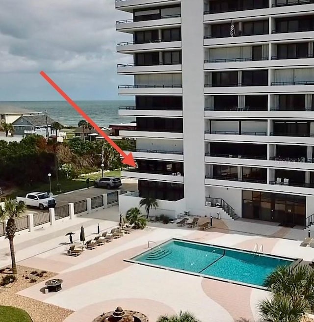 view of pool featuring a water view and a patio area