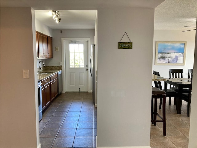 1601 N Central Ave Unit 104, Flagler Beach, FL 32136 - kitchen with a textured ceiling, a sink, light tile patterned floors, and appliances with stainless steel finishes