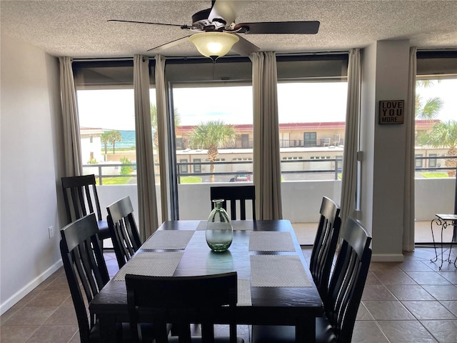 dining room with a textured ceiling, tile patterned flooring, and ceiling fan