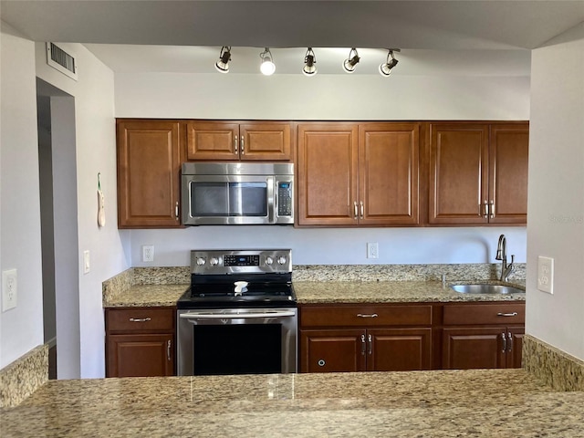 1601 N Central Ave Unit 104, Flagler Beach, FL 32136 - kitchen featuring visible vents, light stone counters, a sink, and stainless steel appliances