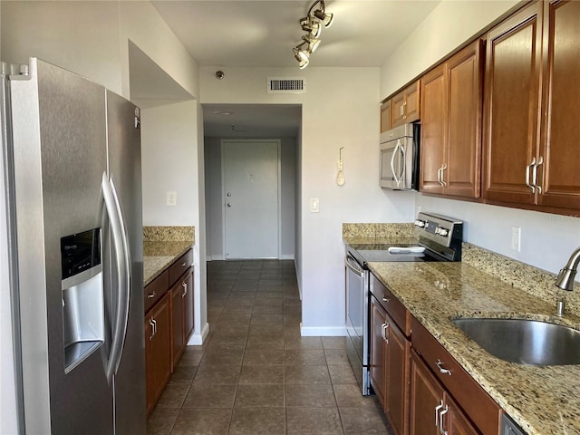 1601 N Central Ave Unit 104, Flagler Beach, FL 32136 - kitchen featuring stainless steel appliances, dark tile patterned flooring, a sink, light stone counters, and visible vents