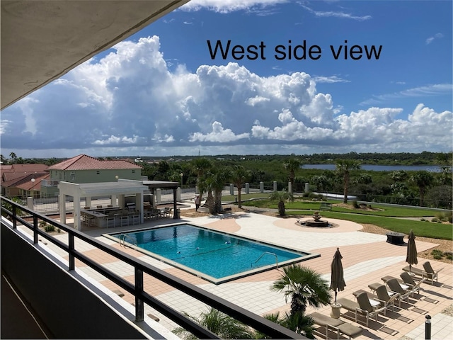 view of swimming pool with a fire pit and a patio area