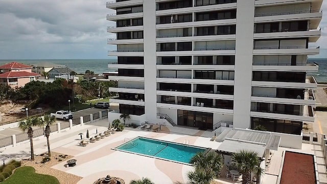 view of swimming pool featuring a water view and a patio area