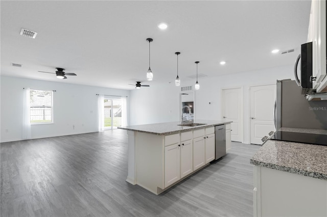 kitchen with white cabinetry, stainless steel appliances, a center island with sink, and sink