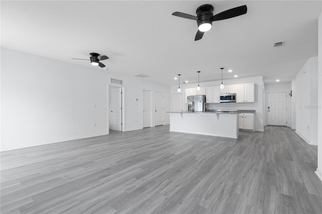 unfurnished living room with light hardwood / wood-style floors and ceiling fan