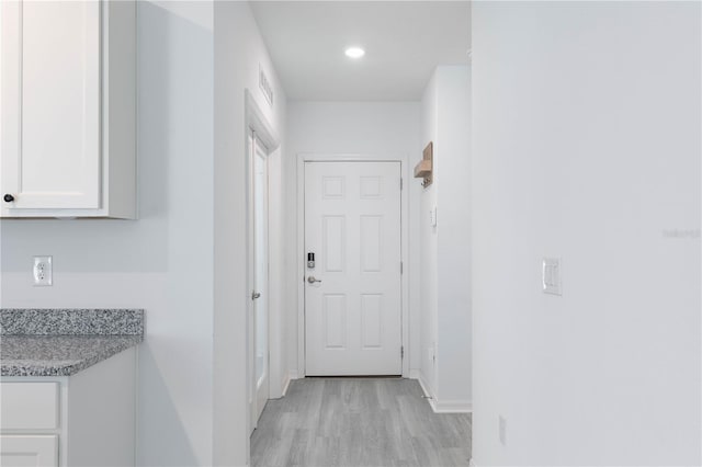 corridor with light hardwood / wood-style floors