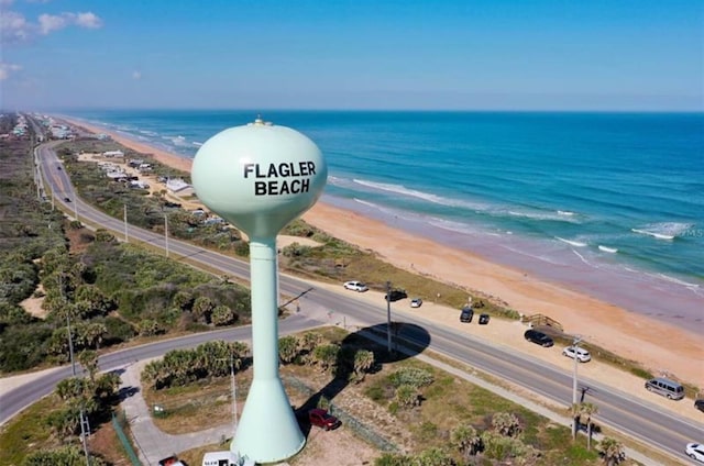 birds eye view of property with a water view and a beach view