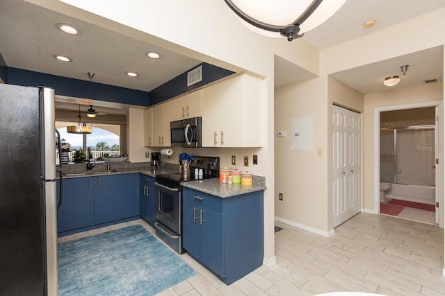 kitchen featuring electric panel, ceiling fan, blue cabinetry, decorative light fixtures, and stainless steel appliances