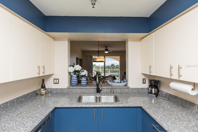 kitchen with ceiling fan, pendant lighting, blue cabinetry, sink, and white cabinetry