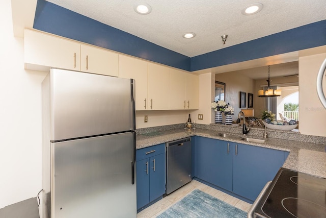 kitchen featuring blue cabinetry, sink, stainless steel appliances, hanging light fixtures, and a textured ceiling