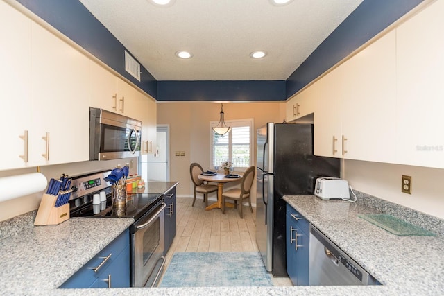 kitchen featuring white cabinets, hanging light fixtures, blue cabinetry, stainless steel appliances, and light hardwood / wood-style floors