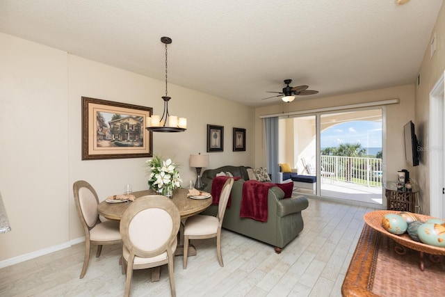 dining space with ceiling fan, a textured ceiling, and light wood-type flooring