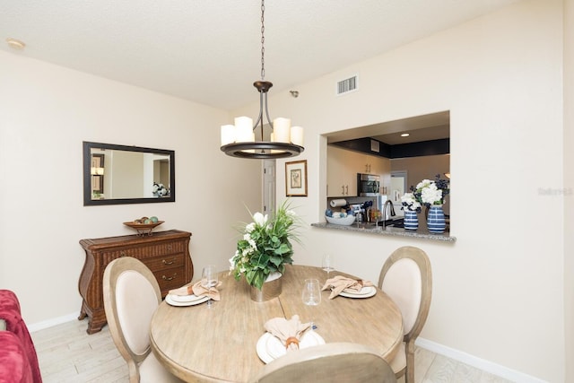 dining room featuring a notable chandelier, light hardwood / wood-style flooring, and sink