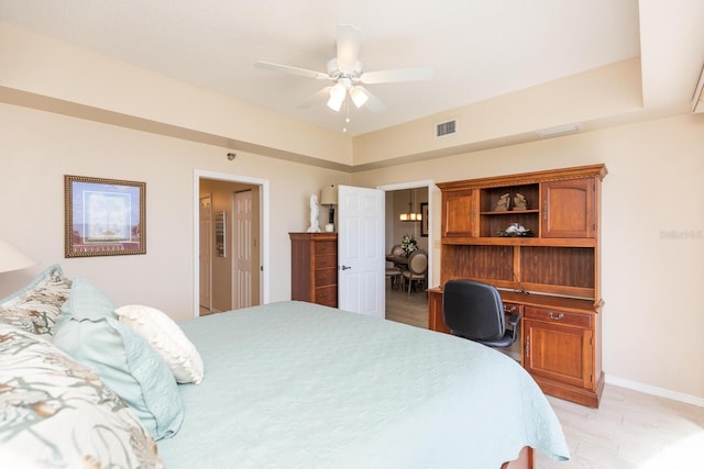 bedroom featuring baseboards, visible vents, a ceiling fan, and built in study area