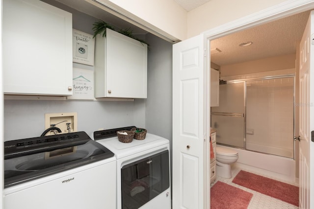 clothes washing area featuring cabinets, washer and dryer, and a textured ceiling