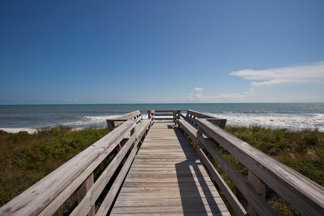 view of community featuring a water view and a beach view