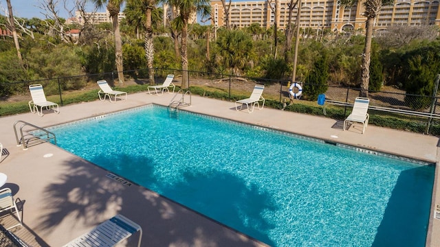 pool with a patio and fence