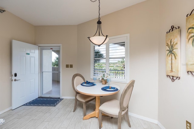 dining area with light wood-style floors and baseboards