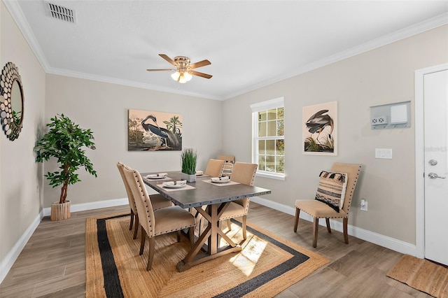 dining area featuring crown molding, ceiling fan, and light wood-type flooring