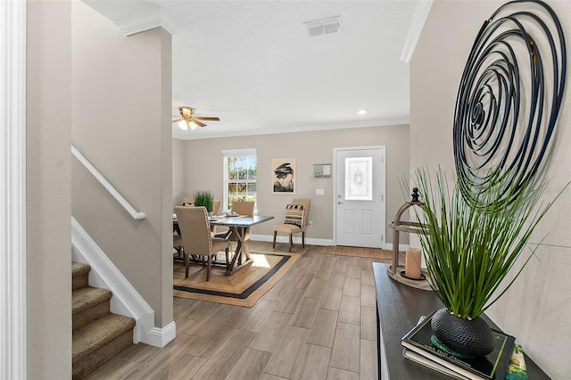 entrance foyer featuring ceiling fan and crown molding