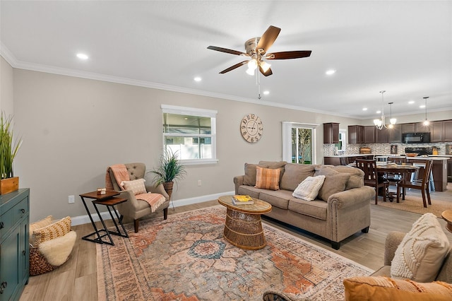 living room featuring ceiling fan, crown molding, and light hardwood / wood-style flooring