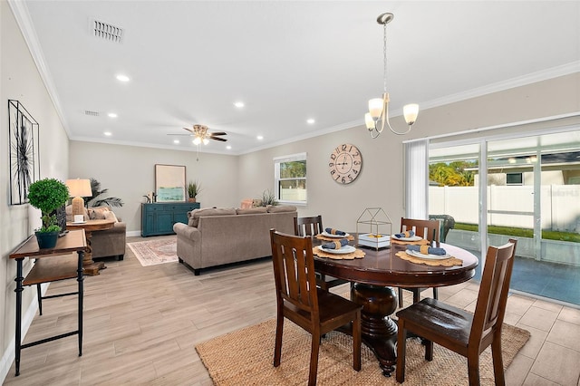 dining space featuring ceiling fan with notable chandelier, plenty of natural light, and crown molding