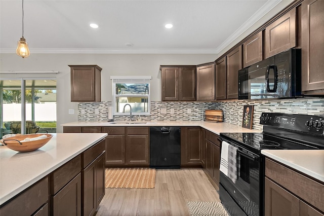 kitchen featuring dark brown cabinets, crown molding, sink, black appliances, and pendant lighting