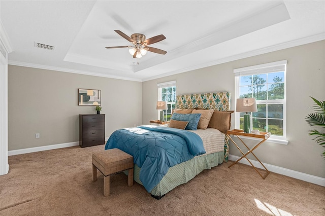 carpeted bedroom with a raised ceiling, ceiling fan, and ornamental molding