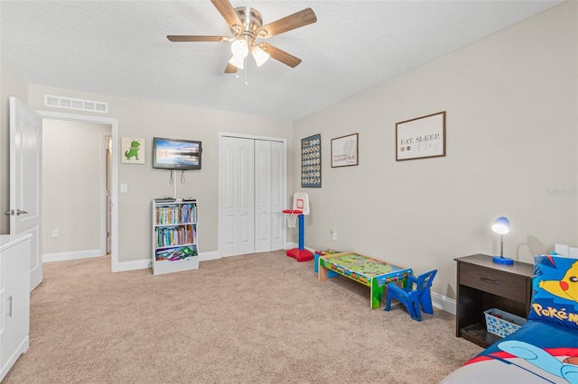 game room featuring ceiling fan, light carpet, and a textured ceiling