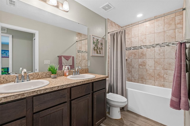 full bathroom with hardwood / wood-style flooring, vanity, toilet, and shower / bath combo with shower curtain