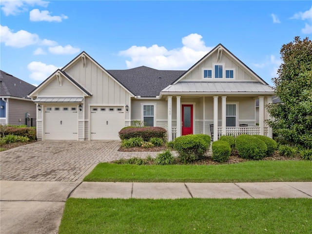 view of front of home featuring a front yard, a porch, and a garage