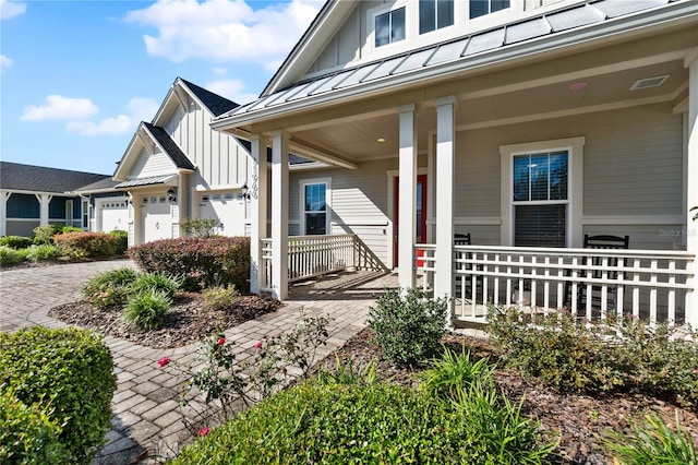 view of exterior entry featuring covered porch and a garage