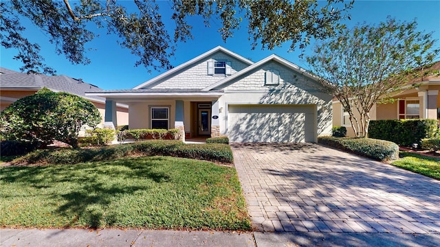 view of front of home with a front yard, decorative driveway, a garage, and stucco siding