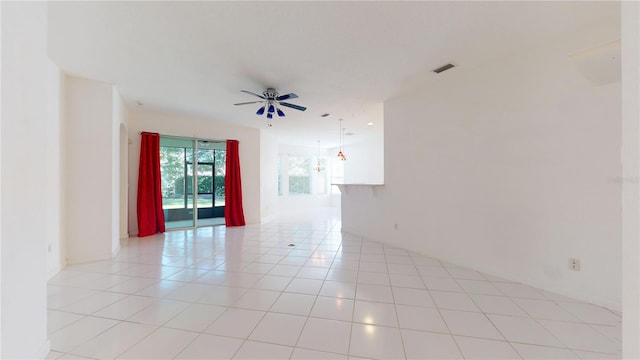 empty room with ceiling fan and light tile patterned floors