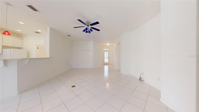 tiled empty room featuring ceiling fan