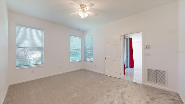 carpeted spare room with ceiling fan