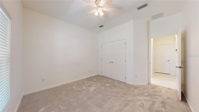 unfurnished bedroom with light carpet, a closet, ceiling fan, and lofted ceiling