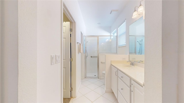 bathroom featuring tile patterned floors, vanity, toilet, and walk in shower