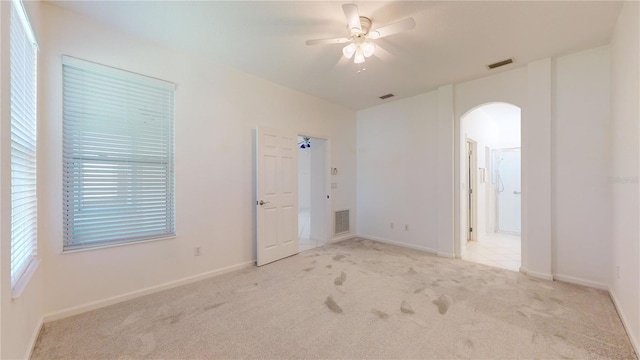 spare room with ceiling fan and light carpet