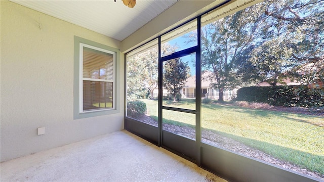 unfurnished sunroom featuring ceiling fan