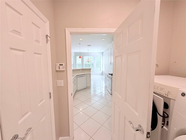 hallway featuring washer / dryer and light tile patterned flooring